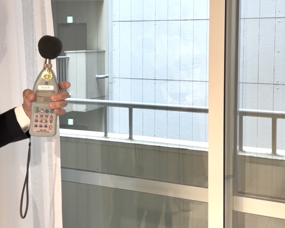 窓際で外部への音漏れを測定する様子